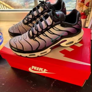 Nike Air Max Plus i blå och svart - Snygga Nike Air Max Plus sneakers i en cool kombination av blå och svart. Skorna har en unik design med vågformade linjer och en bekväm sula för extra komfort. Perfekta för dig som vill ha stil och funktion i ett.