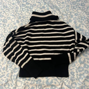Svart och vit randig stickad tröja - Säljer en snygg svart och vit randig stickad tröja med krage och dragkedja. Passar mig som brukar köpa storlek s. 