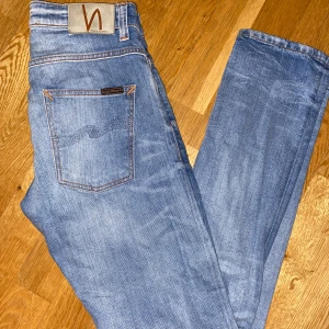 Blå jeans från Nudie Jeans - Snygga jeans från nudie jeans!! Model: grim trim. Skicket är bra utan defekter. Skriv om ni undrar något!! Nypris 1699kr. Mitt pris 399kr