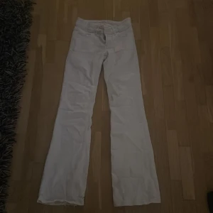 Vita byxor - Säljer ett par vita byxor med medel-låg midja och bootcut-stil. Byxorna har fickor både fram och bak, vilket ger en klassisk look. Perfekta för en stilren outfit. Dom är använda ca 1 gång och bra skick!