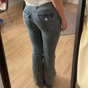 Blå jeans från True Religion - Snygga blå jeans från True Religion med låg midja! Jag fick dessa fina byxorna när jag fyllde år, tyvärr var dessa något för små för mig men de var försent att lämna tillbaka. De köptes för 1300kr och är inte använda en enda gång, helt i nyskick!  #stockholmstil #truereligion #jeans #mode #snyggabyxor
