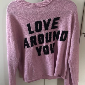 Rosa stickad tröja med text - Rosa stickad tröja med text på, endast använd några gånger då den är för stor.