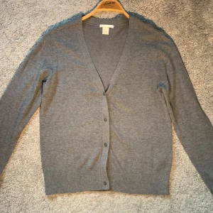 Grå cardigan - Säljer en stilren grå cardigan med knappar framtill.  Passar både till vardags och lite finare tillfällen. Den har en normal passform och är supermjuk och bekväm. Ett måste i garderoben för alla säsonger! S men passar XS, bäst på någon 160-170. Pris: 199 (kan sänkas) 