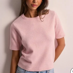 Stickad t-shirt, rosa - Säljer en söt rosa tröja med korta ärmar från Nelly. Använd 1 gång! 