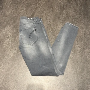 Dondup george - Snygga grå jeans med coola slitningar och en lätt blekt look. De har en klassisk femficksdesign och knappgylf. Perfekta för en avslappnad stil. Storlek 33 sitter mer som 31