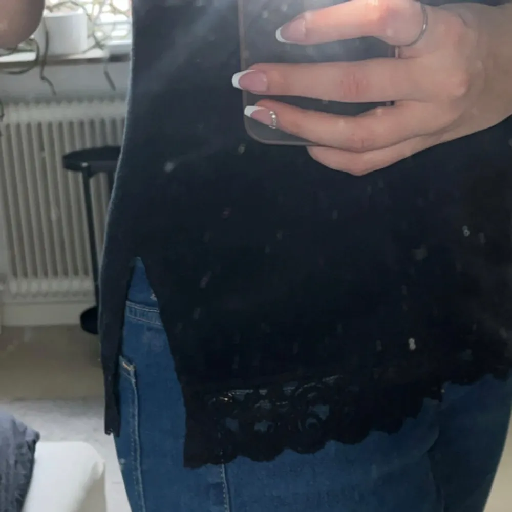 Snyggt svart linne från Vero Moda med spetsdetaljer vid halsringningen och nederkanten. Perfekt för en stilren look. Justerbara axelband för bästa passform. Bra kvalité 😊. Yläosat.