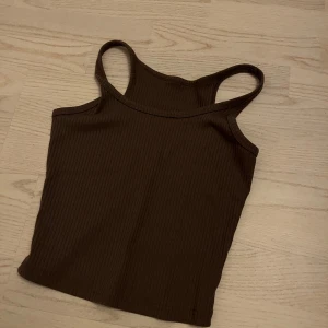 Brun ribbad linnetopp - Snygg brun ribbad linnetopp med smala axelband. 