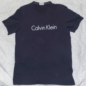 Svart t-shirt från Calvin Klein - Snygg svart t-shirt från Calvin Klein med klassisk logga på bröstet. Tillverkad i mjuk bomull för en bekväm passform. Den är använd ett fåtal gånger och har inga defekter. Den är i storlek M. 