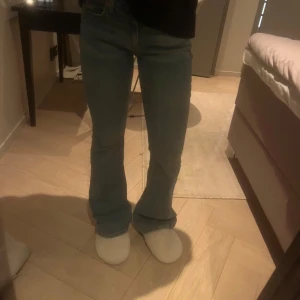 Blå bootcut jeans - Säljer ett par klassiska blå bootcut jeans med normal passform. Perfekta för en avslappnad stil och kan enkelt matchas med olika toppar.