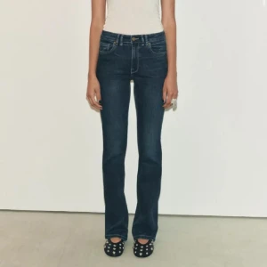 Mörkblå jeansbyxor - Snygga mörkblå jeansbyxor med en klassisk straight passform. Perfekta för en stilren look och kan matchas med det mesta i garderoben. De har en traditionell femficksdesign och knappar i midjan.