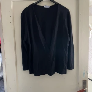 Svart kofta från Etam - Säljer en stilren svart kofta från Etam i storlek 18. Den har en enkel design med knappar framtill och långa ärmar. Perfekt för både vardag och lite finare tillfällen. Passar bra till höst och vinter. 🖤