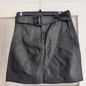 Skinnkjol - Kjol i skinnimitation från Twist and tango. Mycket sparsamt använd, skrynklig pga legat i en låda över sommaren. Storlek 38.