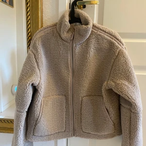NY pilejacka / teddyjacka från HM - Teddyjackan är i ljusbeige färg och i storlek 170 cl. Passar dig som är XS eller S. Passformen är i oversize.