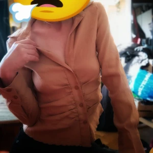 Stilren skjorta med veckade detaljer  - Snygg och stilren skjorta med veckade detaljer framtill i beiget. Helt oanvänd och i nyskick 