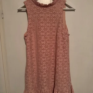Rosa spetsklänning - Snygg rosa klänning i spetsmaterial med söt rosett bak! Som ny! Väldigt bra skick! 🥰 Storlek medium men passar S också!🩷