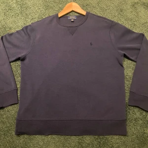 Mörkgrå tröja från Polo Ralph Lauren - Säljer en stilren mörkgrå tröja från Polo Ralph Lauren. Tröjan har långa ärmar och en broderad logga på bröstet. Perfekt för en avslappnad och snygg look.      Tröjan är storlek XL i barnstorlek men sitter som XS.    Skick 8,5/10                                                                        Skriv gärna för fler frågor eller bilder.          