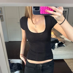Svart tight topp - Snygg svart tight topp med korta ärmar och rund halsringning. Perfekt för en stilren look. Passar bra till både jeans och kjol. XXS men väldigt stretchig så passar upp till S 💗 står ej för postens slarv eller frakt!! 