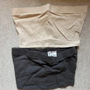 Beige och grå tubtopp från hm - Två stilrena tubtoppar från hm Divided i beige och grått. Perfekta för en enkel och bekväm stil. Tillverkade i mjukt material för en skön passform. 15 kr för båda