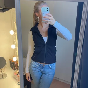 Svart väst från Cross - Snygg svart väst från Cross med dragkedja och coola snörningsdetaljer på sidorna. Perfekt för en stilren look. Den är i storlek XS men passar mig som bär S. Hör av dig vid intresse!💗