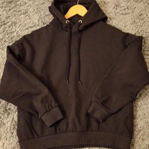 Svart hoodie från 157 - Säljer en klassisk svart hoodie från 157 i storlek M. Den har en bekväm passform med långa ärmar och en justerbar huva med snören. Perfekt för en avslappnad stil.