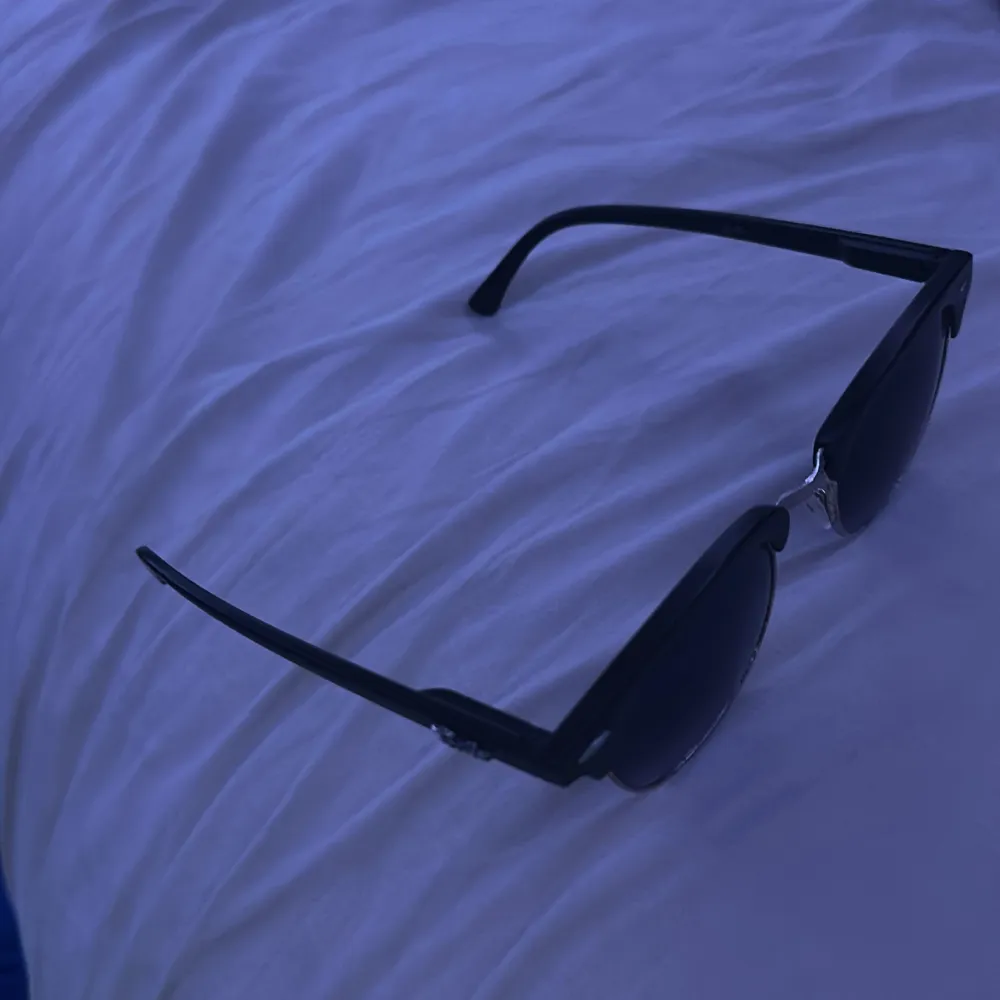 Snygga svarta solglasögon från Ray-Ban med klassisk design. De har en svart båge och mörka glas som ger en cool look. Perfekta för soliga dagar och en stilren outfit.. Asusteet.