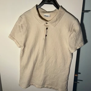 Beige kortärmad pikétröja från John Henric - Säljer en stilren beige pikétröja från John Henric. Tröjan har korta ärmar och tre knappar vid kragen. Perfekt för en avslappnad men ändå uppklädd look. Står L men är som en barn 152-158. Perfekt för ditt barn eller dig själv. Nypris 1400kr men går och förhandla priset 