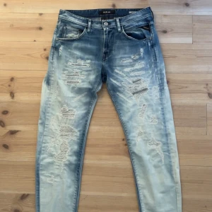 Blå jeans från Replay - Snygga unika blå jeans från Replay med slitna detaljer och en cool tvättad look. 