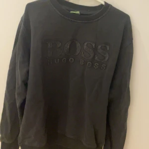 Svart sweatshirt från Hugo Boss - Säljer en svart sweatshirt från Hugo Boss med broderad logga på framsidan. Tröjan har långa ärmar och en rund halsringning. Perfekt för en stilren och bekväm look, inte använd så ofta, väldigt stilig och snygg till det mesta, XXL men sitter som L och fungerar till XL. Pris går att diskuteras.
