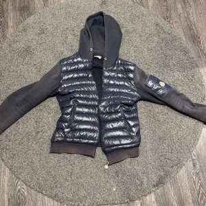 Moncler jacka - Tjena!! Säljer en stilren moncler jacka/cardigan som är perfekt nu till slutet av vintern och våren🌨️☀️ Skick 6/10 då den är lite urtvättad.Har även ett litet trasigt märke men man märker ej av det. Storlek M men sitter även bra på S. Modellen är 187cm lång. Köpt för 5000kr