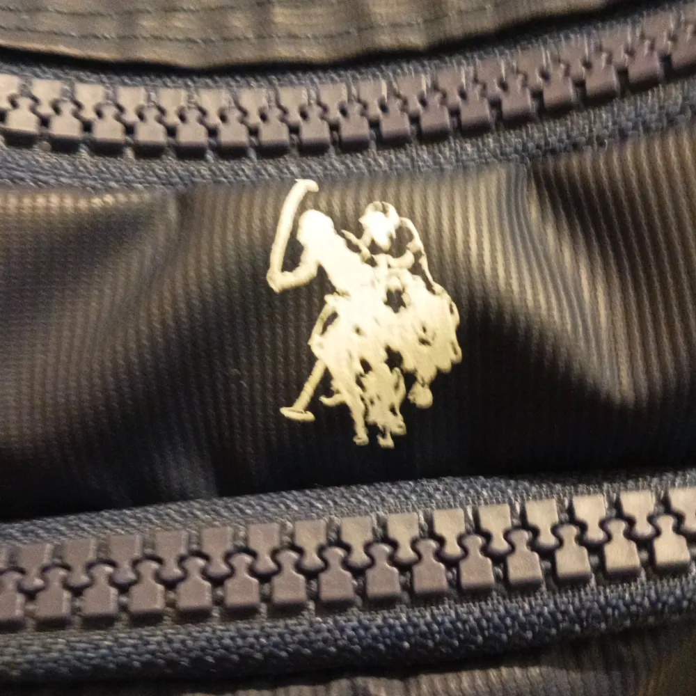 Säljer en snygg mörkblå axelväska från USPA Sport med flera praktiska fack och dragkedjor. Väskan har röda detaljer och en justerbar axelrem. Perfekt för att hålla ordning på dina saker när du är på språng. Använt 1 gång. Laukut & Käsilaukut.