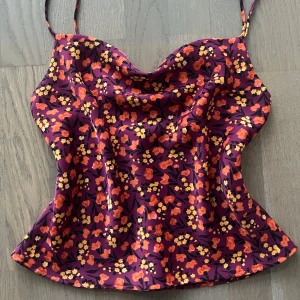 Zara topp  - Snygg blommig satinlinne med smala axelband och ett färgglatt mönster i rött, gult och lila. Är i mycket bra skick🫶