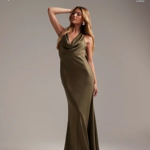 Olivgrön balklänning - Olivgrön maxiklänning med draperad halterneck-halsringning från ASOS brudtärnekollektion. Den är storlek 32 men passar mig som aldrig har det annars! Har aldrig använts och har kvar lappar. 