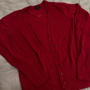 Röd kofta  - Snygg röd/vinröd kofta med knappar framtill. Materialet är jätteskönt mot huden. Storlek xs men funkar även som s. Köpt från lindex.