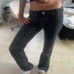 Svarta bootcut jeans - Snygga svarta bootcut jeans med låg midja och klassisk femficksdesign. Perfekta för en avslappnad stil. De har en knapp och dragkedja framtill.och har brända detaljer upptill,använda c 2 ggr,MÅTT—38 cm rakt över,innerbenslängden är 78cm