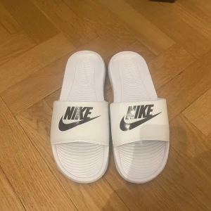 Vita nike tofflor - Säljer ett par vita Nike tofflor helt nya