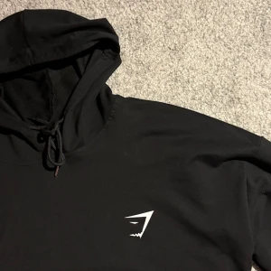 Gymshark hoodie  - Svart Gymshark luvtröja i storlek S, skick 10/10 och inga tecken på användning. Ett perfekt plagg för både träning och vardag.