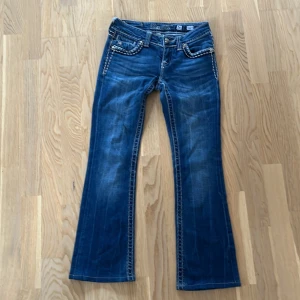 Blå jeans från miss me - Snygga blå jeans från Miss Me med unika broderade detaljer på bakfickorna. Byxorna är bootcut och är dekorerade med kontrasterande sömmar. Perfekt säljer eftersom de inte passade, priset kan diskuteras! 