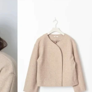 Beige ulljacka  - Säljer en stilren beige ulljacka. Jackan har en minimalistisk design med en omlottstängning och långa ärmar. Perfekt för en elegant och enkel look. Storlek S!