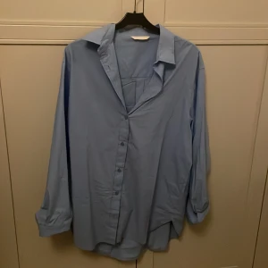 Blå skjorta - Snygg blå skjorta med klassisk krage och knappar framtill. Perfekt för en stilren look.!🥰🥰
