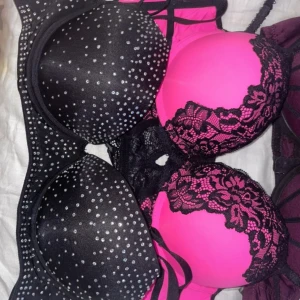 Svart och rosa bh med spets och glitter - Två bh:ar i svart och rosa. Den ena har glittrigt mönster och den andra har spetsdetaljer. Perfekt för att lägga till lite glamour i vardagen.