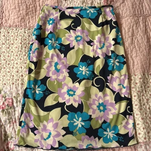 Blommig kjol i pastellfärger - SUPERSÖT tajt kjol med blommönster!! Säljer pga jag inte använt den så mycket. Hittar ingen lapp som anger storleken men midjemåttet tvärs över är ca 35 cm och längden är ca 58 cm. Köpte den second hand och den är fortfarande som ny! Tycker den är perfekt för att få lite retro känsla 