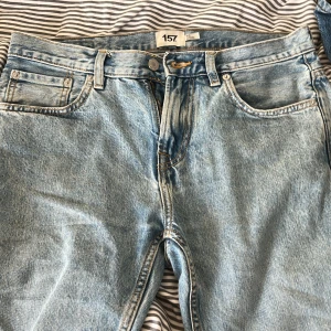 Ljusblå jeans från 157 - Snygga ljusblå jeans från 157 med klassisk femficksdesign och knappgylf. Perfekta för en avslappnad stil. De har en normal passform och är tillverkade i slitstarkt denim.