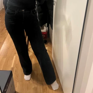 Svarta jeansbyxor - Snygga jeans med raka ben. Klassisk design med fem fickor och knappgylf. Perfekta för en stilren look.