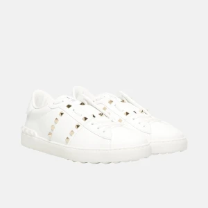 Vita sneakers med nitar från Valentino - Snygga vita sneakers från Valentino med ikoniska nitar längs sidorna. Skorna har en stilren design med snörning och en bekväm sula. Perfekta för att ge din outfit en lyxig touch. Säljer denna som företagsmedhjälpare, vilket innebär att kvitto, originalförpackning och övriga tillbehör ingår. Produkten är 100 % äkta och helt ny, utan något tryck eller märkning.