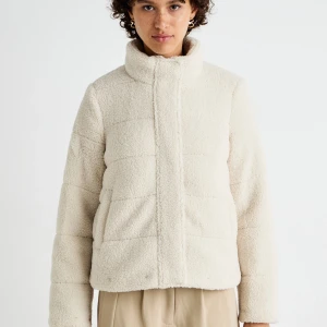 Beige teddyjacka - Mysig beige teddyjacka med hög krage och dragkedja framtill. Perfekt för kyliga dagar med sin quiltade design och långa ärmar. Jackan har en avslappnad passform och ger en trendig look. Storlek 36 men passar även 34!💗