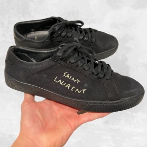 Saint laurent skor canvas svarta - •Saint Laurent Canvas skor svarta. Riktigt clean & unik modell! Skick: 8/10, Inga skador! Väldigt fint skick och använts sällan och flitigt. ALLA SLITNINGAR ÄR DESIGN Å VART DÄR SEN NYSKICK! Storlek: 40, YSL är stora i storlek så sitter som 40-41. Äkta givetvis✅ Vid köp medföljer Original boxen, YSL dustbag och YSL mini påse. Hör av dig vid frågor eller funderingar, mvh Oliver🙂