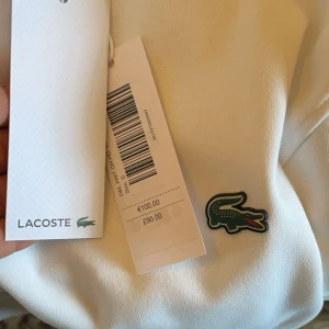 Vit hoodie från Lacoste - Säljer en vit hoodie från Lacoste. Säljer tröja för den är liten för mig. Har inte använd den mycket 