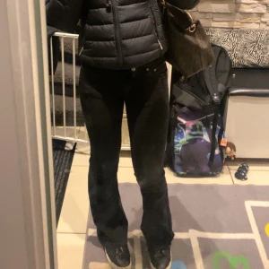 Svarta utsvängda jeans - Snygga svarta jeansbyxor med en utsvängd passform. Lite slitna längst nere men inget man lägger märke till, annars jättefina. 