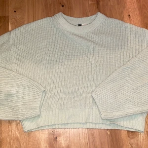 Ljusgrön stickad tröja - Mysig ljusgrön stickad tröja med rund hals och långa ärmar. Perfekt för kyligare dagar med sin bekväma och avslappnade passform. En stilren och enkel design som passar till många tillfällen.