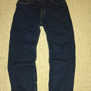 Mörkblå jeans från McGordon - Säljer ett par mörkblå jeans från McGordon. De har en klassisk design med fem fickor och kontrastsömmar. Byxorna är högmidjade och tillverkade i stretchigt material för extra komfort.